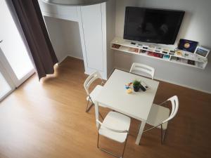 マテーラにあるLa Casettina nei Sassiのテレビ付きの客室で、白いテーブルと椅子が備わります。