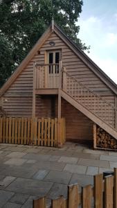 a wooden house with a staircase on the side of it at The Barn Tarporley in Tarporley