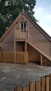 een houten huis met een trap aan de zijkant bij The Barn Tarporley in Tarporley