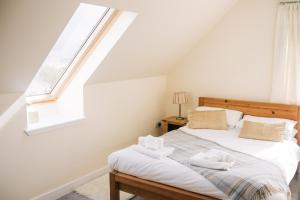 a bedroom with a bed with two towels on it at Sea Shimmer in Portree