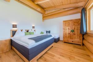 フィーバーブルンにあるFerienhaus Obwallhofの木製の天井が特徴のベッドルーム1室(大型ベッド1台付)