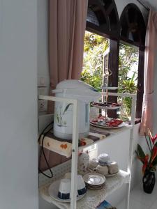 a kitchen with a shelf with dishes on it at D Heart Homestay in Bangkok