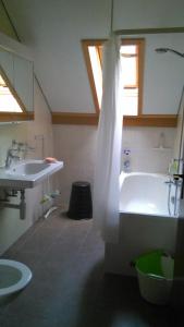 ein Badezimmer mit einer weißen Badewanne und einem Waschbecken in der Unterkunft La Petite Fleur in Enges