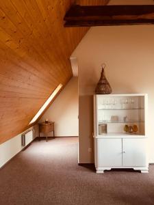 an attic room with a white cabinet and a wooden ceiling at LilO- mittendrin und ganz dicht bei in Itzehoe