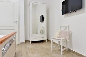ein Badezimmer mit einem weißen Schrank und einem Stuhl in der Unterkunft Moselhof Ferienwohnungen in Bruttig-Fankel