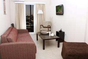- un salon avec un canapé et une table basse dans l'établissement De Los Arroyos Apart Hotel, à San Nicolás de los Arroyos