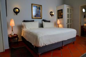 a bedroom with a large white bed with two lamps at Casa Marly in Xochitepec +43 photos
