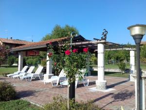 a group of chairs and a pergola with a bunch of roses at Eli's House in Bolzano Novarese