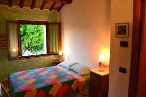 a bedroom with a colorful bed and a window at B&B Le Tamerici in San Giorgio di Pesaro