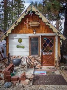a small log cabin with a grill and a door at Cabins 4 Less, No Fees in Big Bear Lake