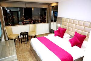 a bedroom with a large bed with pink pillows at Petra Sella Hotel in Wadi Musa