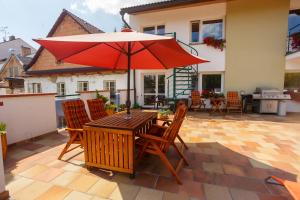 - une table et des chaises en bois avec un parasol sur la terrasse dans l'établissement Pension Kraus, à Litomyšl