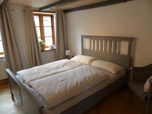 Schlafzimmer mit einem Bett und einem Fenster in der Unterkunft Alter Krämerladen von 1732 in Friedrichstadt