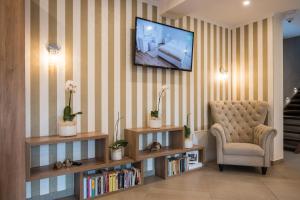 a living room with a chair and a television on a wall at Pensiunea David in Târgu-Mureş