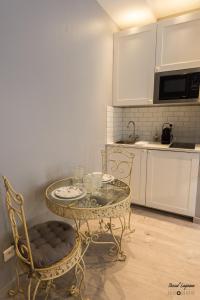 a kitchen with a glass table and two chairs at Cocoon amoureux de Beaune in Beaune