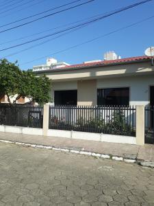 a white fence in front of a house at Casa de Praia Navegantes - 100 metros do mar in Navegantes