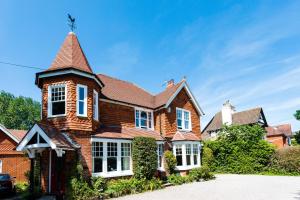 a large brick house with a turret at The Lawn Guest House Gatwick in Horley