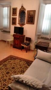 a living room with a bed and a desk and a television at lake house in Mezzanego