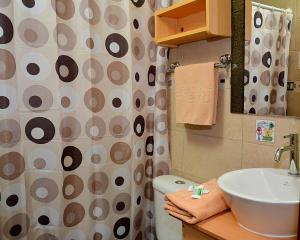 y baño con lavabo, aseo y cortina de ducha. en Hostal Terra 1 - ANDALUCÍA, en Quito