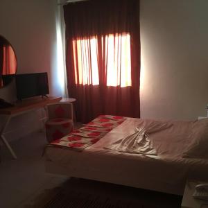 a bedroom with a bed and a window with a curtain at Aylimas Family Hotel in Monastir