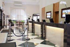 a lobby with a check in counter and chairs at The World Vila Olímpia in Sao Paulo