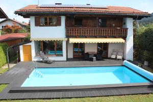 uma casa com piscina em frente a uma casa em Haus am Pool - Wohlfühloase em Ohlstadt