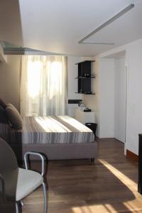 ein Schlafzimmer mit einem Bett, einem Stuhl und einem Fenster in der Unterkunft The Queen's Room in Neapel