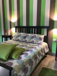 1 dormitorio con 1 cama con rayas verdes y blancas en Le Donne di Giannino, en Rende