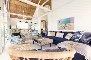 a living room with a blue couch and a table at marAmar Bungalows by STH in Santa Teresa Beach +58 photos
