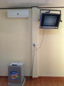 a room with a tv on the wall next to a wall at Cocosand Hotel in Mui Ne