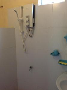 uma casa de banho com um chuveiro e um telefone na parede em Cocosand Hotel em Mui Ne