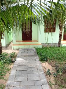 una passerella di fronte a un edificio con palme di Cocosand Hotel a Mui Ne