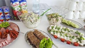 une table avec des assiettes de nourriture et des bols de salade dans l'établissement Willa Ankoria, à Władysławowo