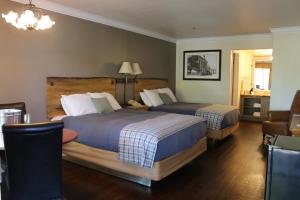 a hotel room with two beds and a table and chairs at Historian Inn in Gardnerville