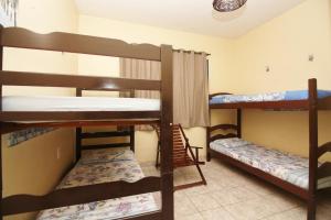 a dorm room with three bunk beds in it at Pousada Fortaleza Aeroporto House in Fortaleza