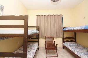 a room with three bunk beds and a window at Pousada Fortaleza Aeroporto House in Fortaleza