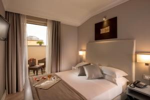 a hotel room with a bed and a window at Ludovisi Palace Hotel in Rome +43 photos