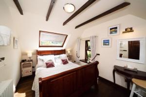 1 dormitorio con cama, escritorio y ventana en The Old Coach House, en Pitlochry