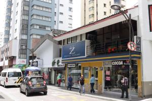 a busy city street with people walking on the sidewalk at Hotel Zandu in Pereira