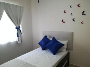 a bedroom with a bed with blue pillows and a window at Playa del Carmen in Playa del Carmen