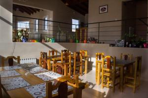 comedor con mesas y sillas de madera en Edelweiss Hostel en El Calafate