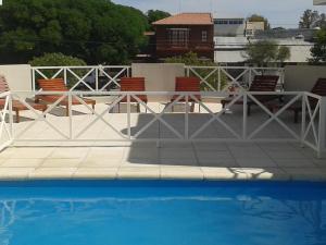 una mesa blanca y sillas junto a una piscina en Terraza al Sol en Las Grutas