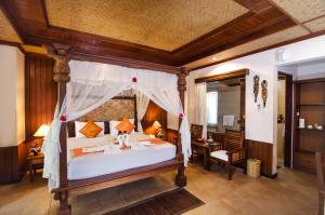 a bedroom with a large bed with a canopy at Sri Phala Resort & Villa in Sanur