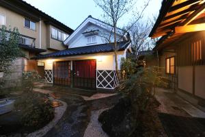 a house with a red door and a building at Oyado Uraku in Yufu
