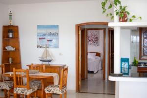 een woonkamer met een tafel en stoelen en een slaapkamer bij Ayfa Apartment in Punta de Mujeres