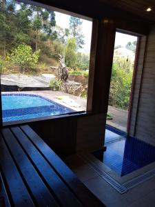 vistas a la piscina desde la ventana de una casa en Chalé Vale da Mata, en Visconde De Maua