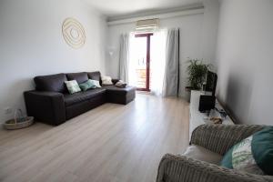 a living room with a couch and a table at Ericeira Lounge Seaside Apartment in Ericeira