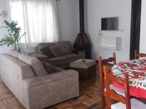 ein Wohnzimmer mit Sofa und Tisch in der Unterkunft Casa da Vó Nelsi in Gramado