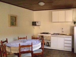 a kitchen with a table and a kitchen with a table and chairs at Casa da Vó Nelsi in Gramado