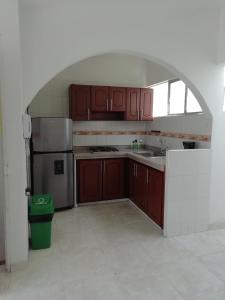 una cocina con armarios de madera y un gran arco en Los Juanes apto con terraza, en Buga 3 fotos más
